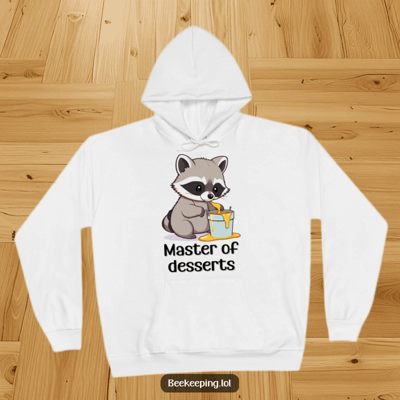 Funny Raccoon Honey Hoodie, cozy and warm, a determined raccoon gently scooping honey into a small pail, humorous woodland themed clothing.