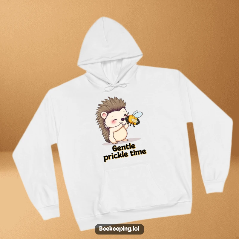 Funny hoodie featuring a wobbly hedgehog gently trying to brush a bee, emphasizing a theme of caring and soft interactions.